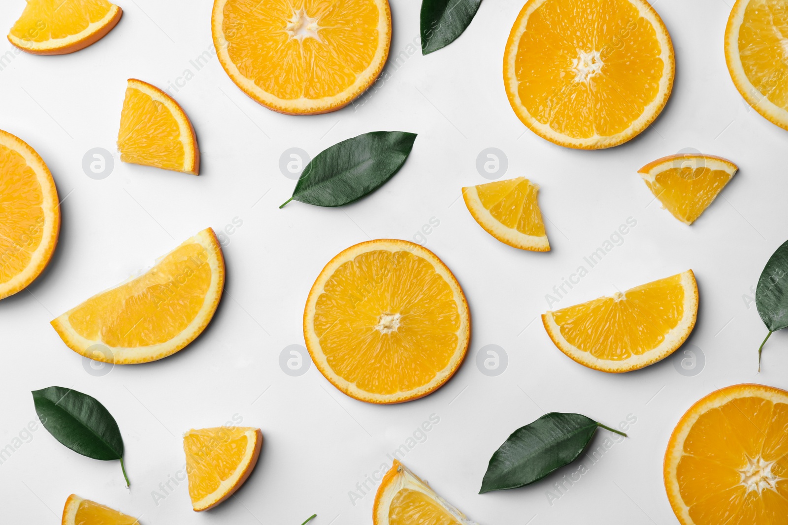 Photo of Fresh orange slices and leaves on white background, top view