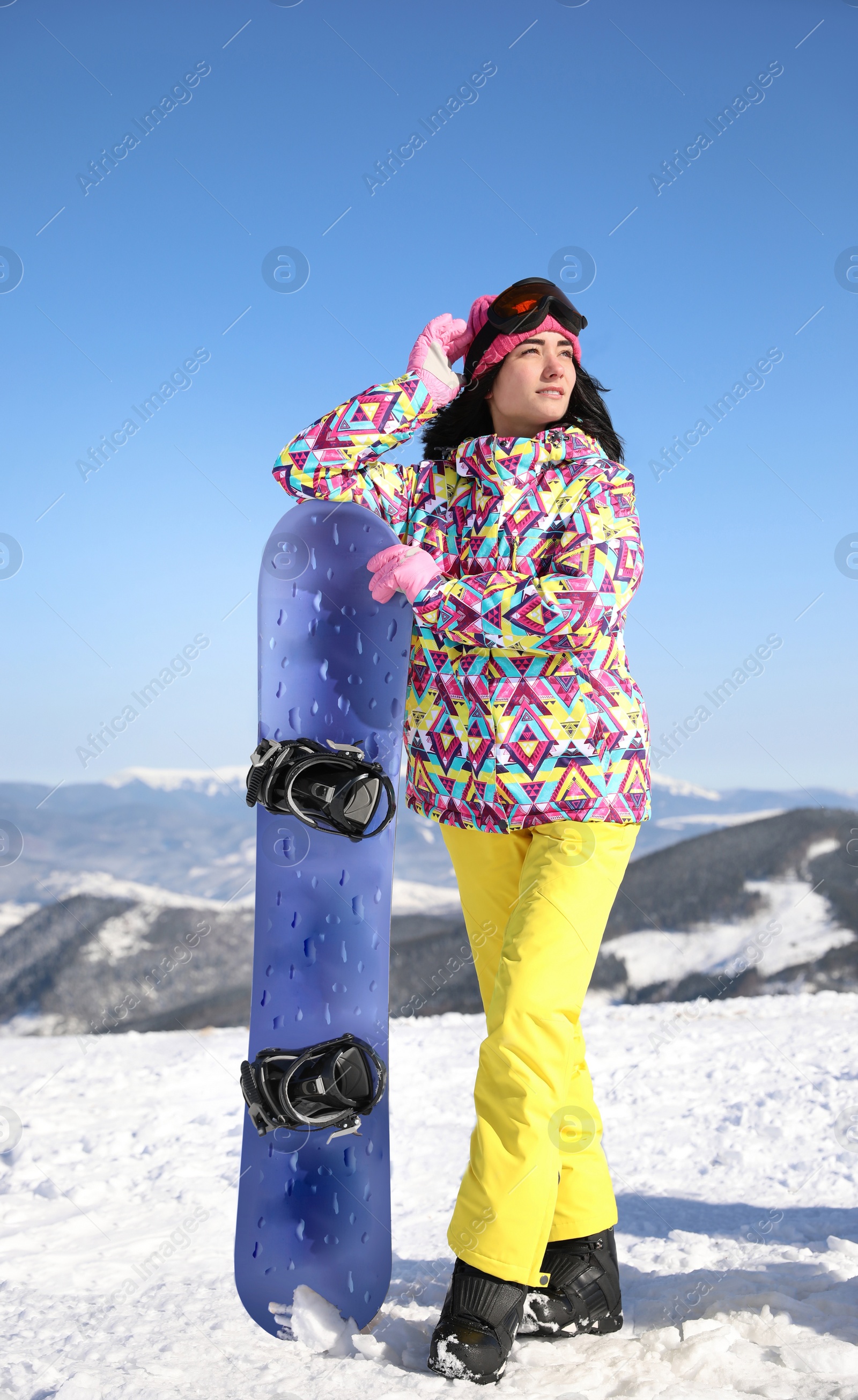 Photo of Young woman with snowboard outdoors. Winter vacation