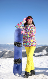 Young woman with snowboard outdoors. Winter vacation