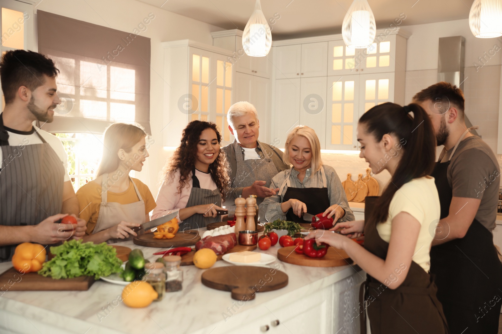 Photo of Happy people cooking food together in kitchen