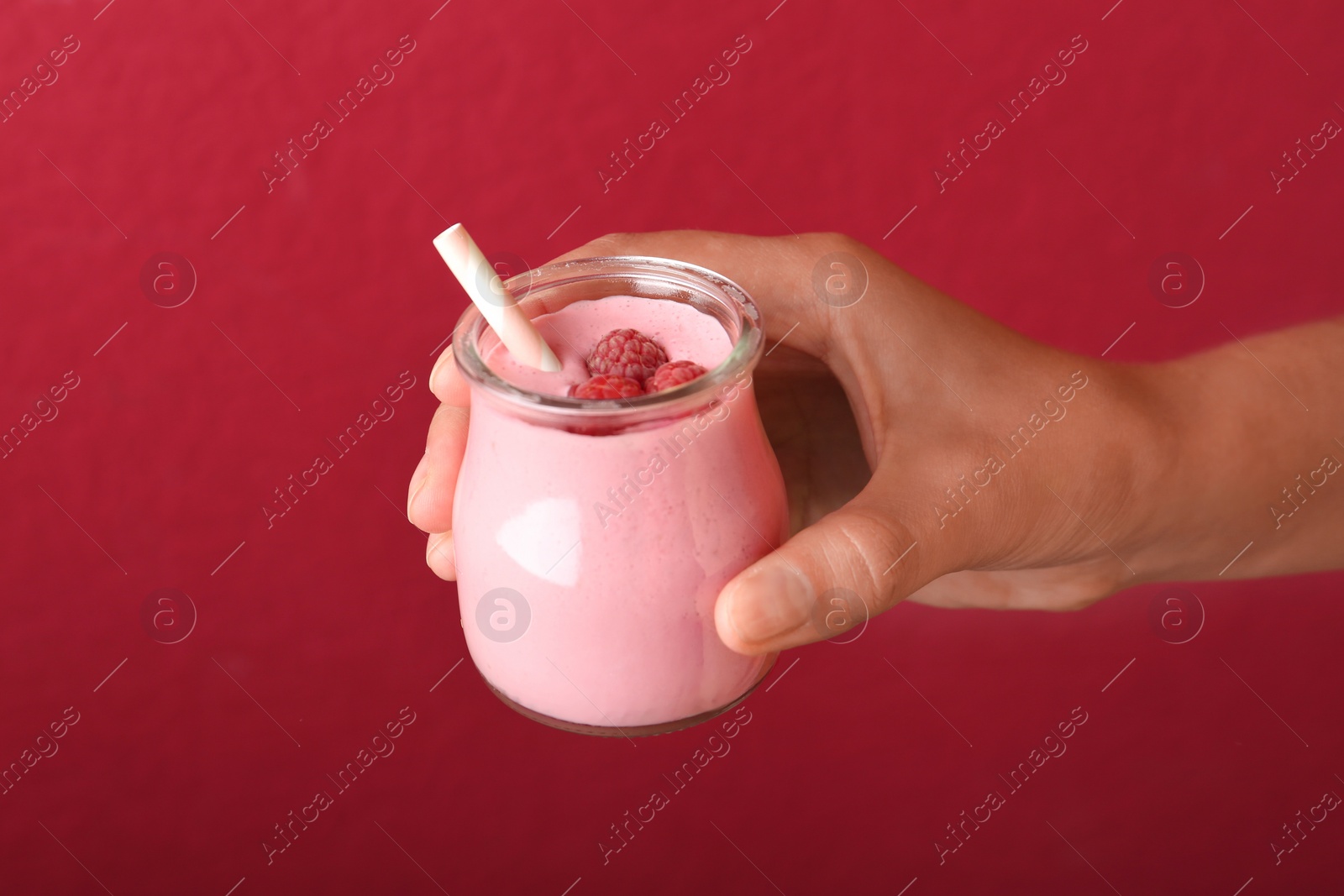 Image of Woman with tasty raspberry smoothie on red background, closeup