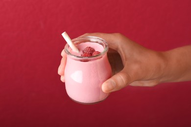 Image of Woman with tasty raspberry smoothie on red background, closeup