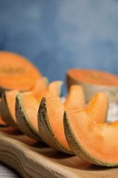Photo of Slices of ripe cantaloupe melon in wooden tray on table