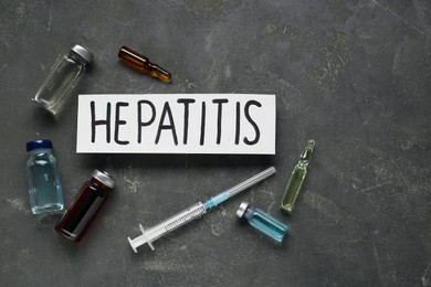 Word Hepatitis and medical supplies on grey table, flat lay. Space for text