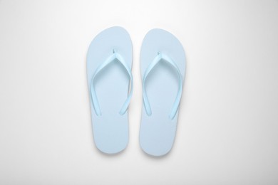 Light blue flip flops on white background, top view