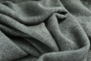 Stylish grey cashmere scarf as background, closeup
