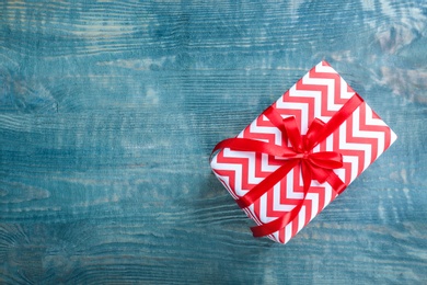 Elegant gift box with bow on wooden background, top view