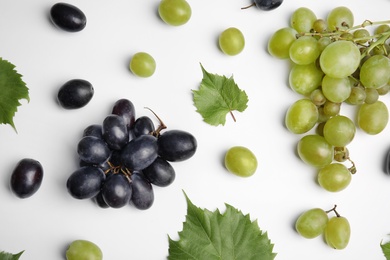 Photo of Fresh ripe juicy grapes and leaves on white background, top view