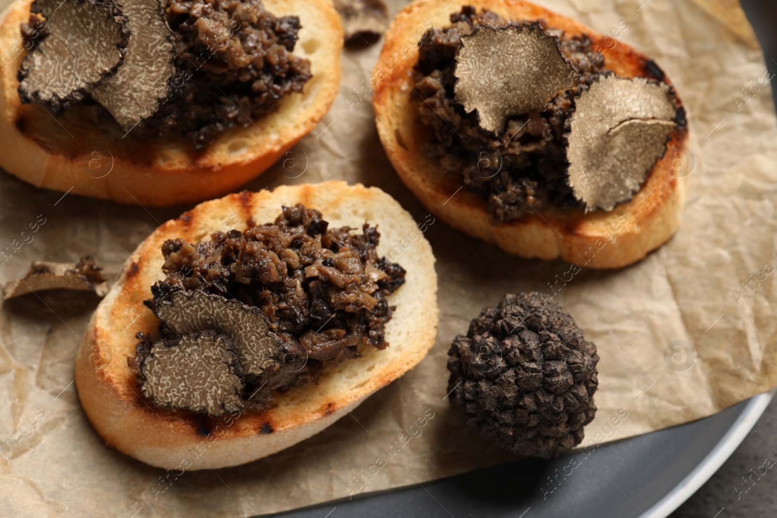 Photo of Delicious bruschettas with truffle sauce on plate, closeup