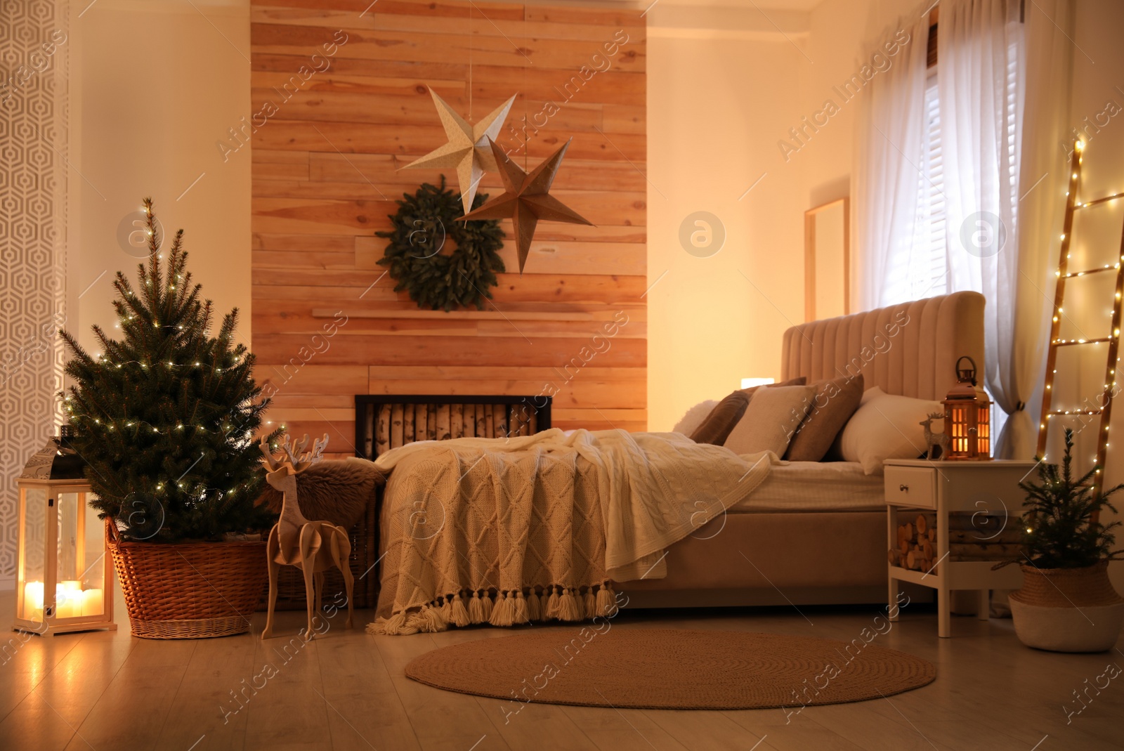 Photo of Beautiful decorated Christmas tree with fairy lights in bedroom interior