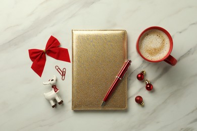 Stylish planner, cup of aromatic coffee and Christmas decor on white marble background, flat lay. New Year aims