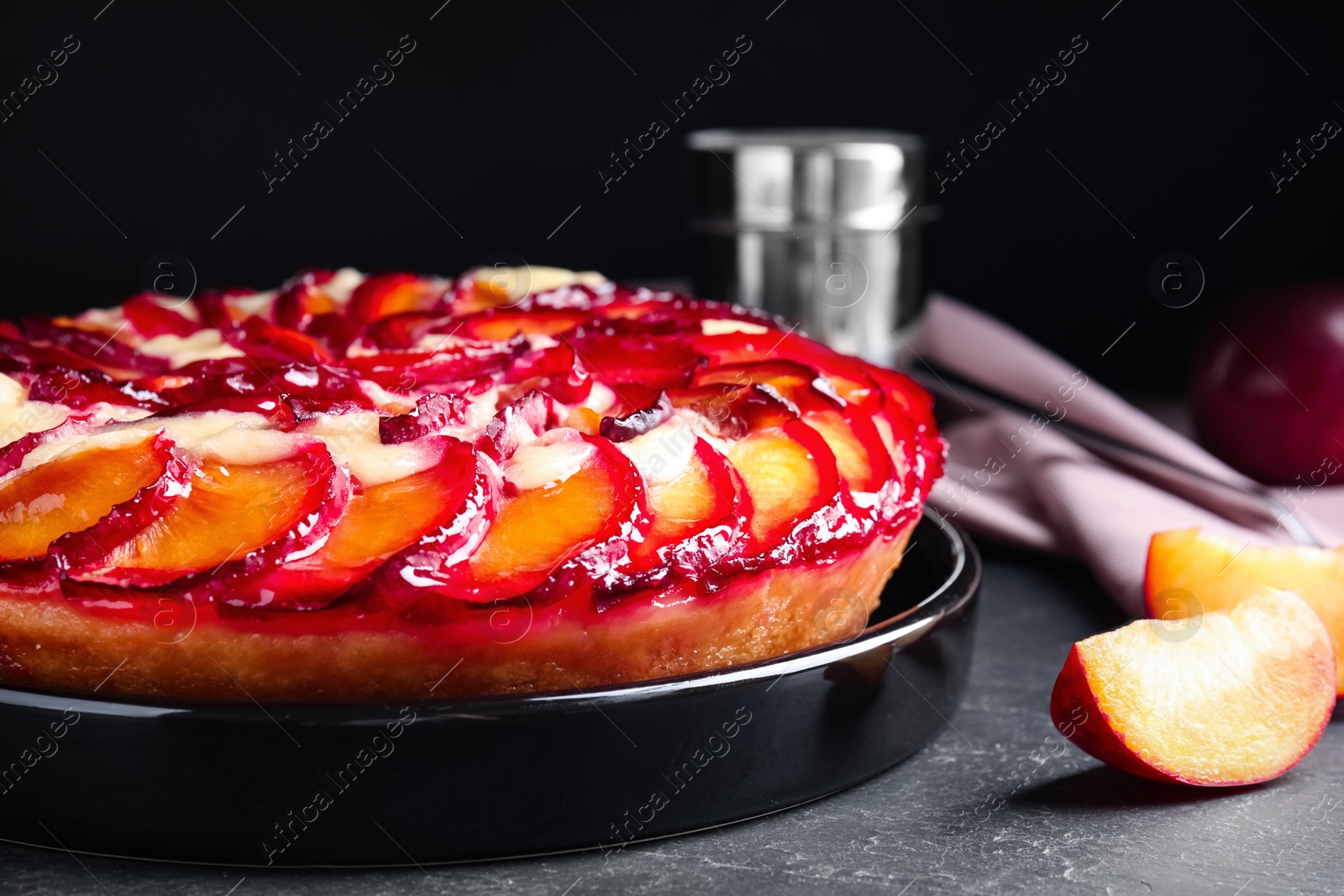 Photo of Delicious cake with plums on grey table, closeup