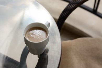 Ceramic cup of aromatic coffee on glass table outdoors, above view. Good morning