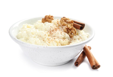 Photo of Creamy rice pudding with cinnamon and walnuts in bowl on white background