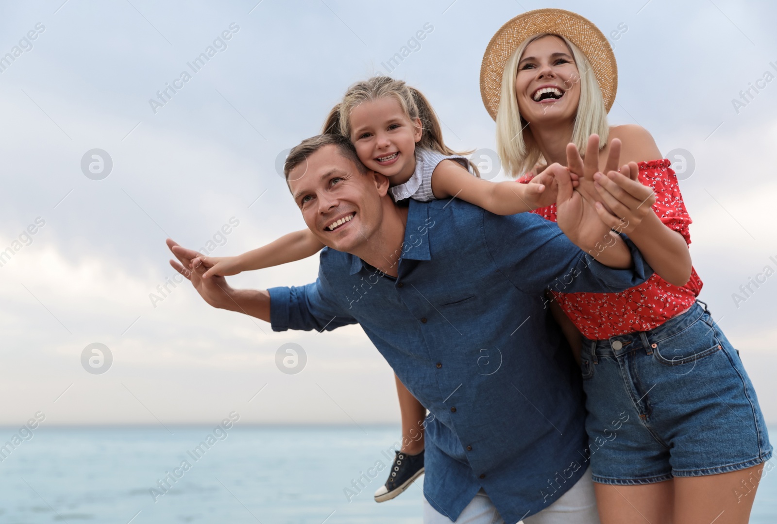 Photo of Happy family spending time together near sea on sunny summer day