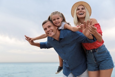 Photo of Happy family spending time together near sea on sunny summer day