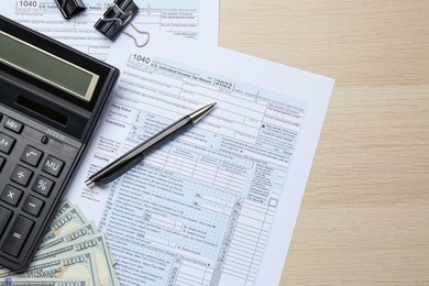 Photo of Calculator, money, documents and pen on wooden table, flat lay with space for text. Tax accounting