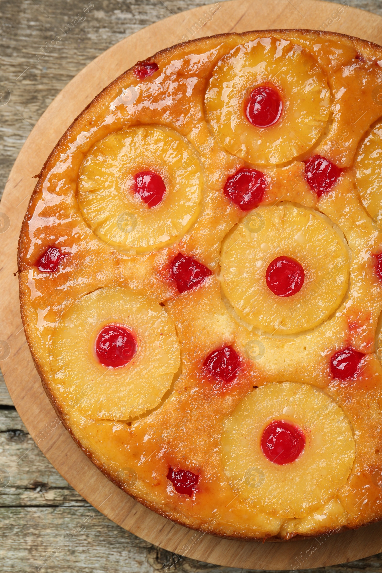 Photo of Tasty pineapple cake with cherries on wooden table, top view