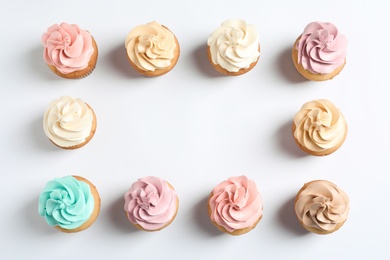 Flat lay composition with delicious birthday cupcakes and space for text on white background