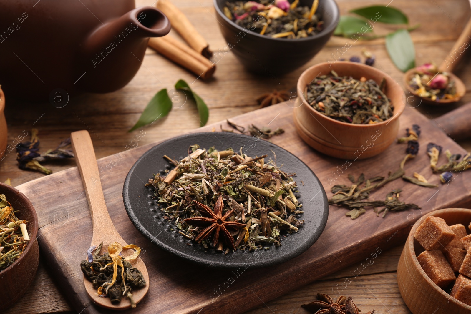 Photo of Different dry aromatic teas on wooden table