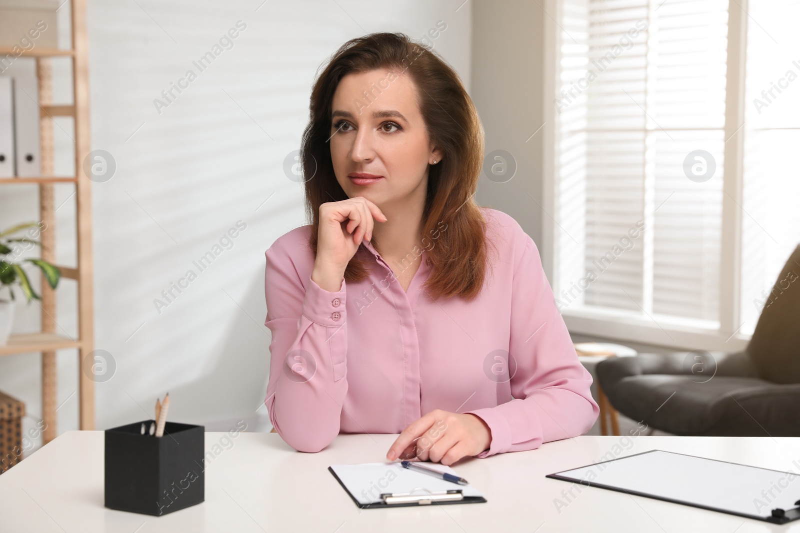 Photo of Portrait of psychotherapist at white table in office
