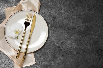 Photo of Stylish setting with elegant cutlery on grey table, top view. Space for text