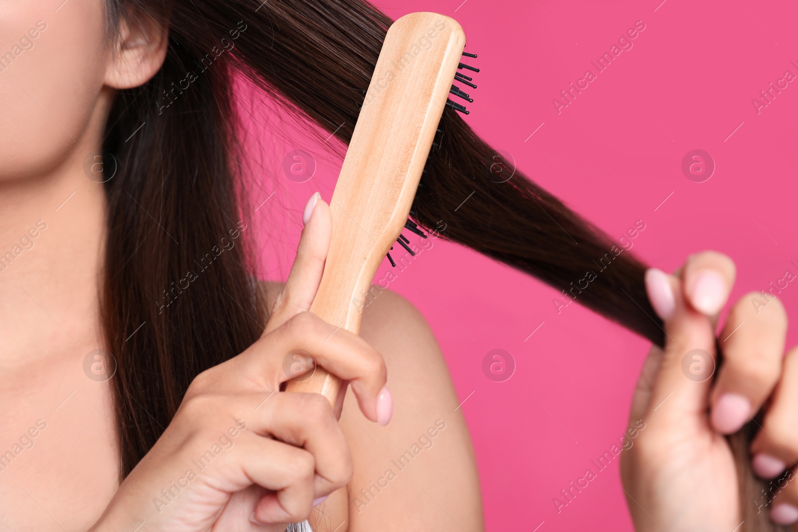 Photo of Woman with hair brush on color background, closeup