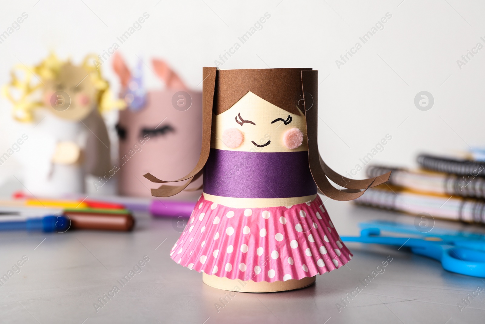 Photo of Toy doll made of toilet paper hub on grey table