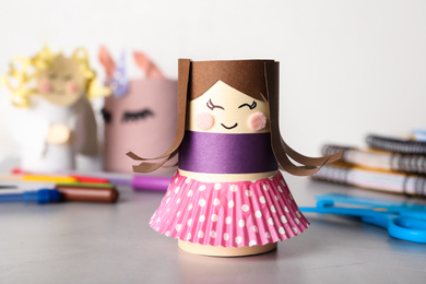 Photo of Toy doll made of toilet paper hub on grey table