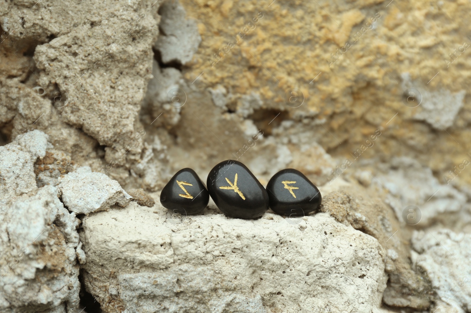 Photo of Black runes on stone outdoors. Old Germanic alphabet