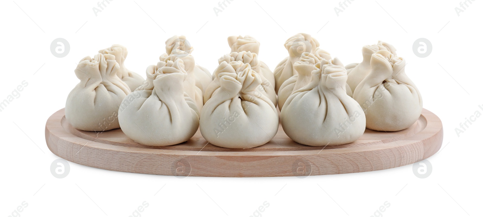 Photo of Wooden board with uncooked khinkali (dumplings) isolated on white. Georgian cuisine