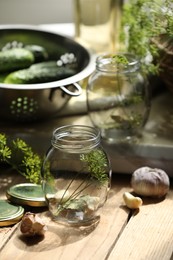 Photo of Empty glass jar and ingredients prepared for canning on wooden table