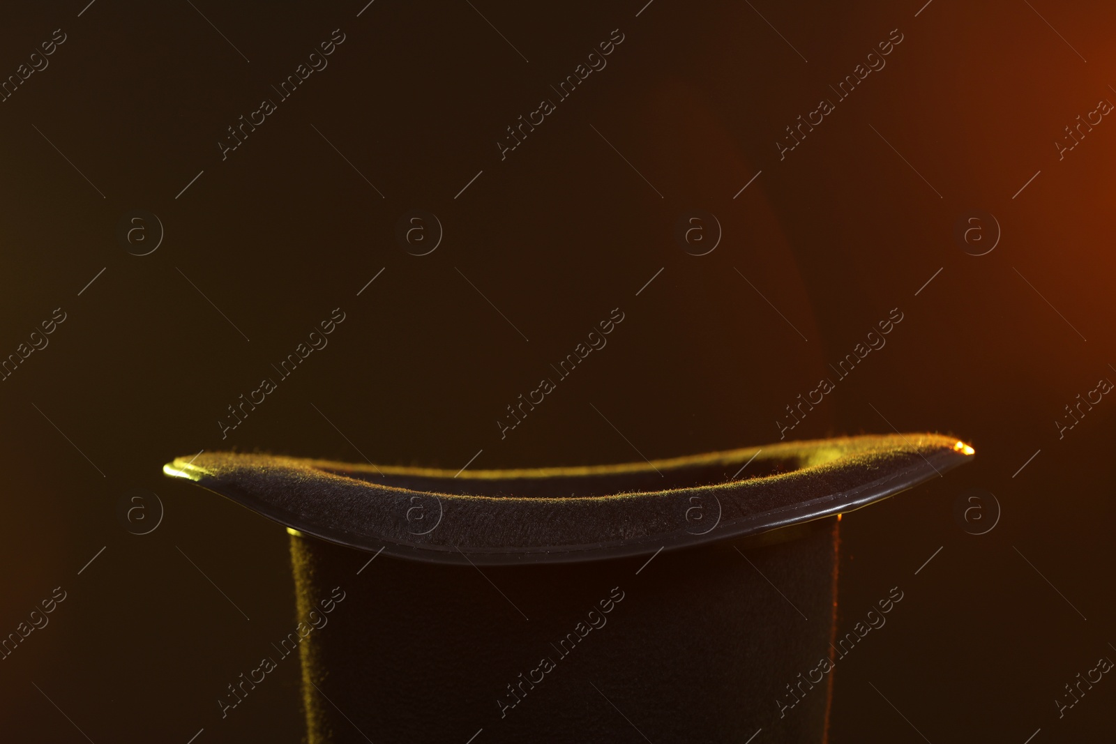 Photo of Black magician's hat on dark background, closeup. Space for text