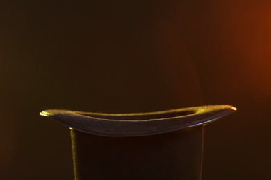 Photo of Black magician's hat on dark background, closeup. Space for text