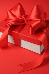 Photo of Beautiful gift box with bow on red background, closeup