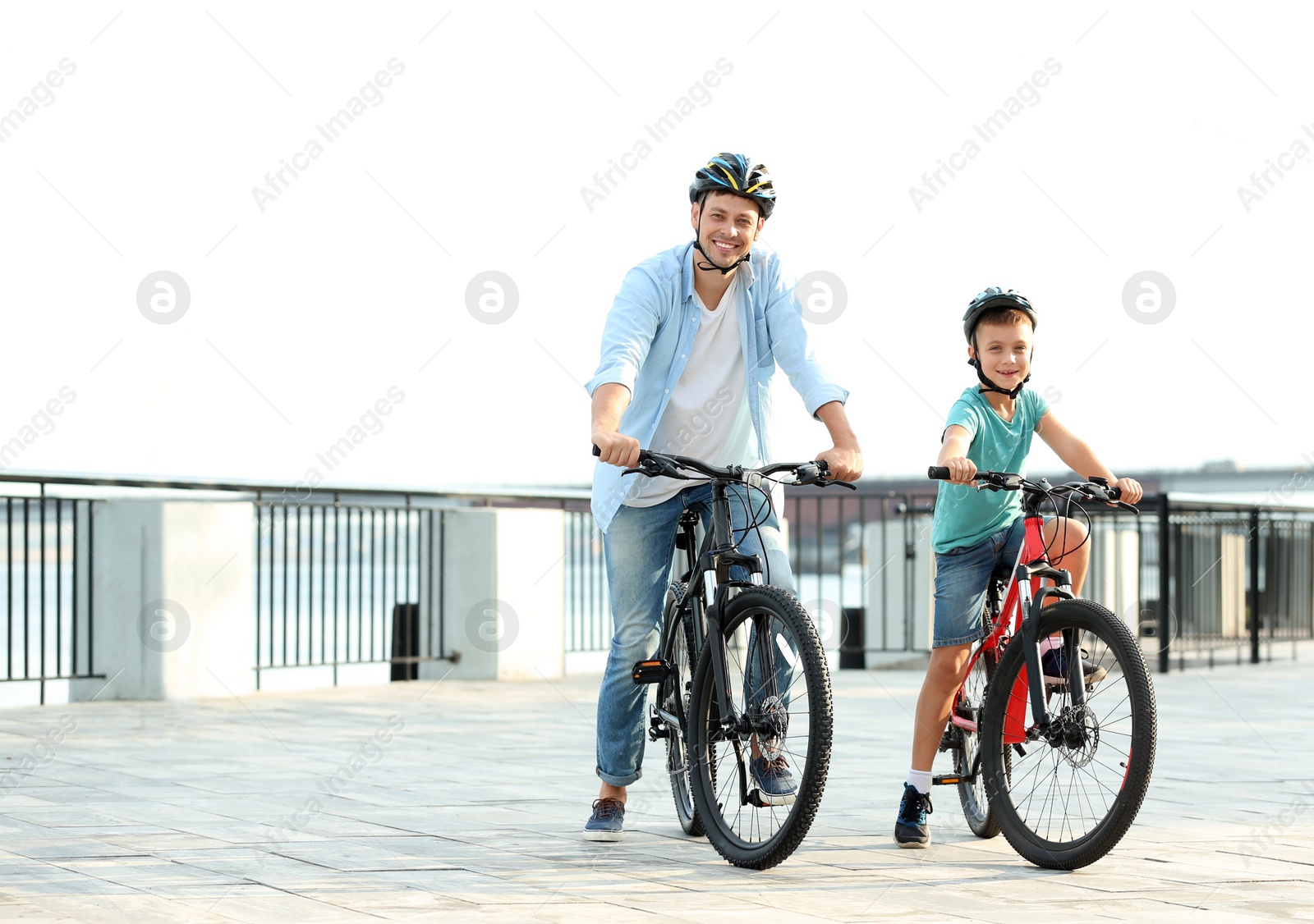 Photo of Dad and son riding bicycles together outdoors