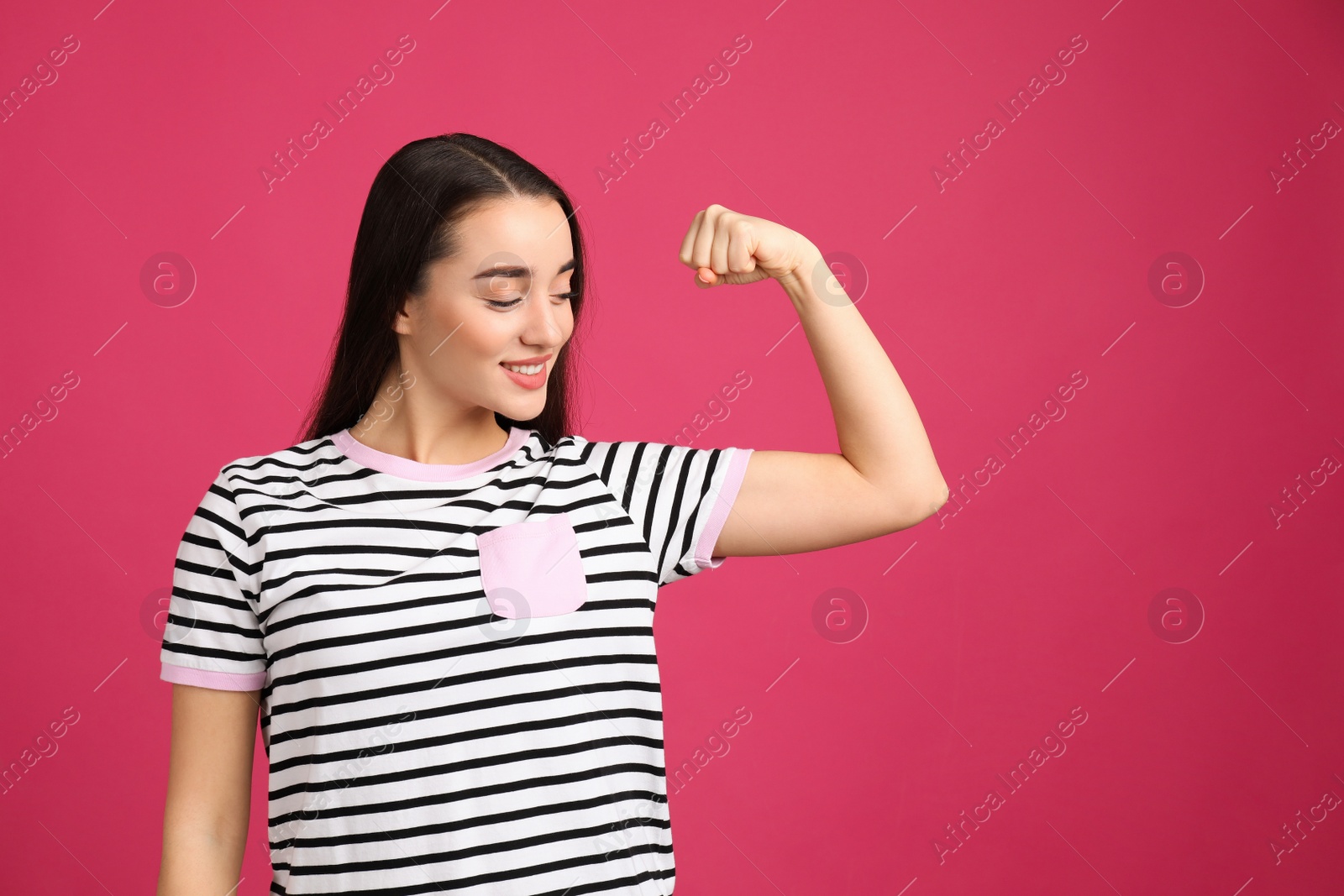 Photo of Strong woman as symbol of girl power on pink background. 8 March concept