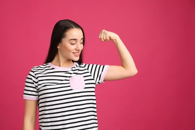 Strong woman as symbol of girl power on pink background. 8 March concept