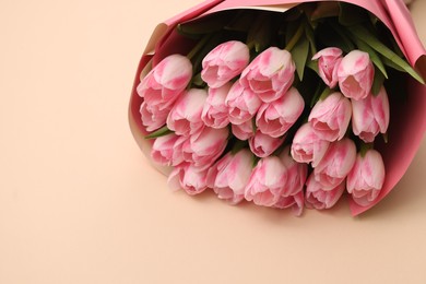 Photo of Beautiful bouquet of fresh pink tulips on beige background