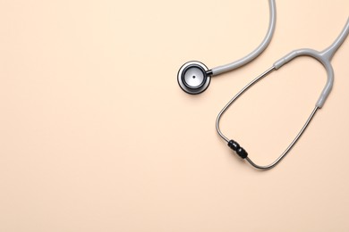 Photo of Stethoscope on beige background, top view. Space for text