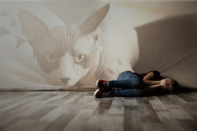 Image of Scared little girl lying on floor indoors. Suffering from ailurophobia (irrational fear of cats)
