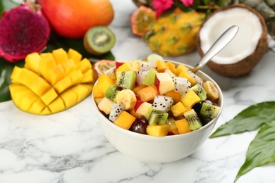 Delicious exotic fruit salad on white marble table