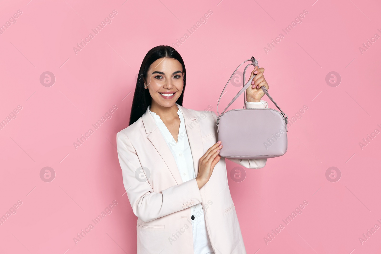 Photo of Beautiful young woman with stylish bag on pink background