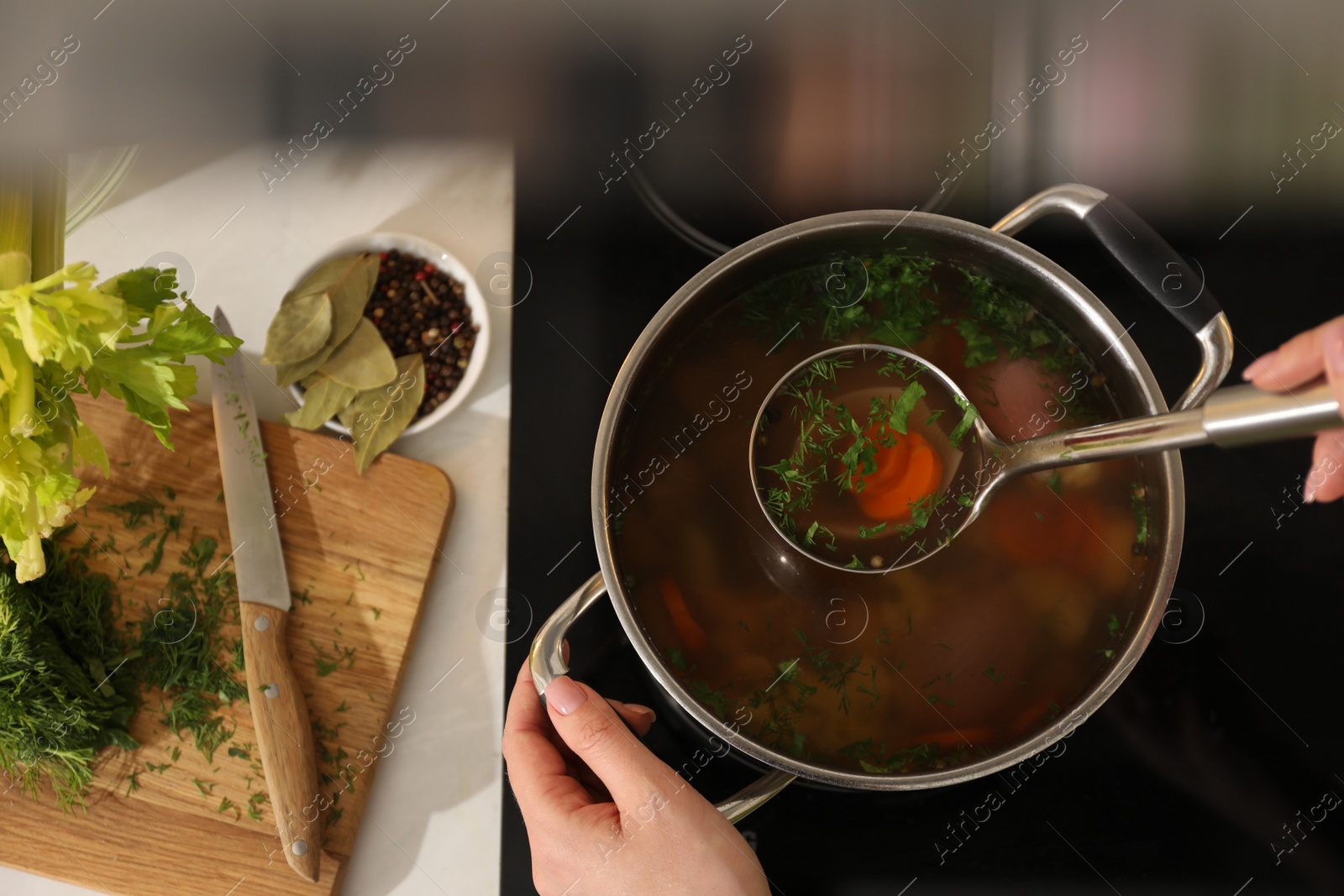 Photo of Woman making bouillon on stove, top view. Homemade recipe