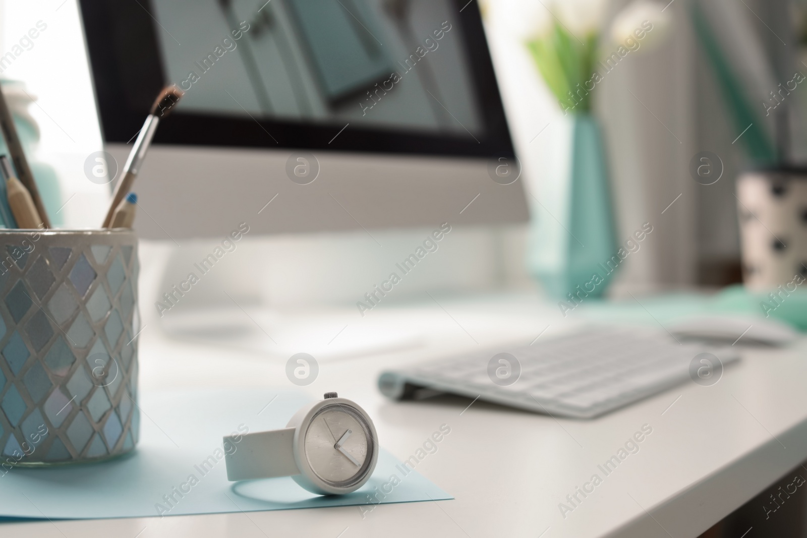 Photo of Stylish workplace with modern computer on desk, space for text. Focus on watch