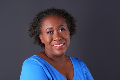 Portrait of happy African-American woman on black background
