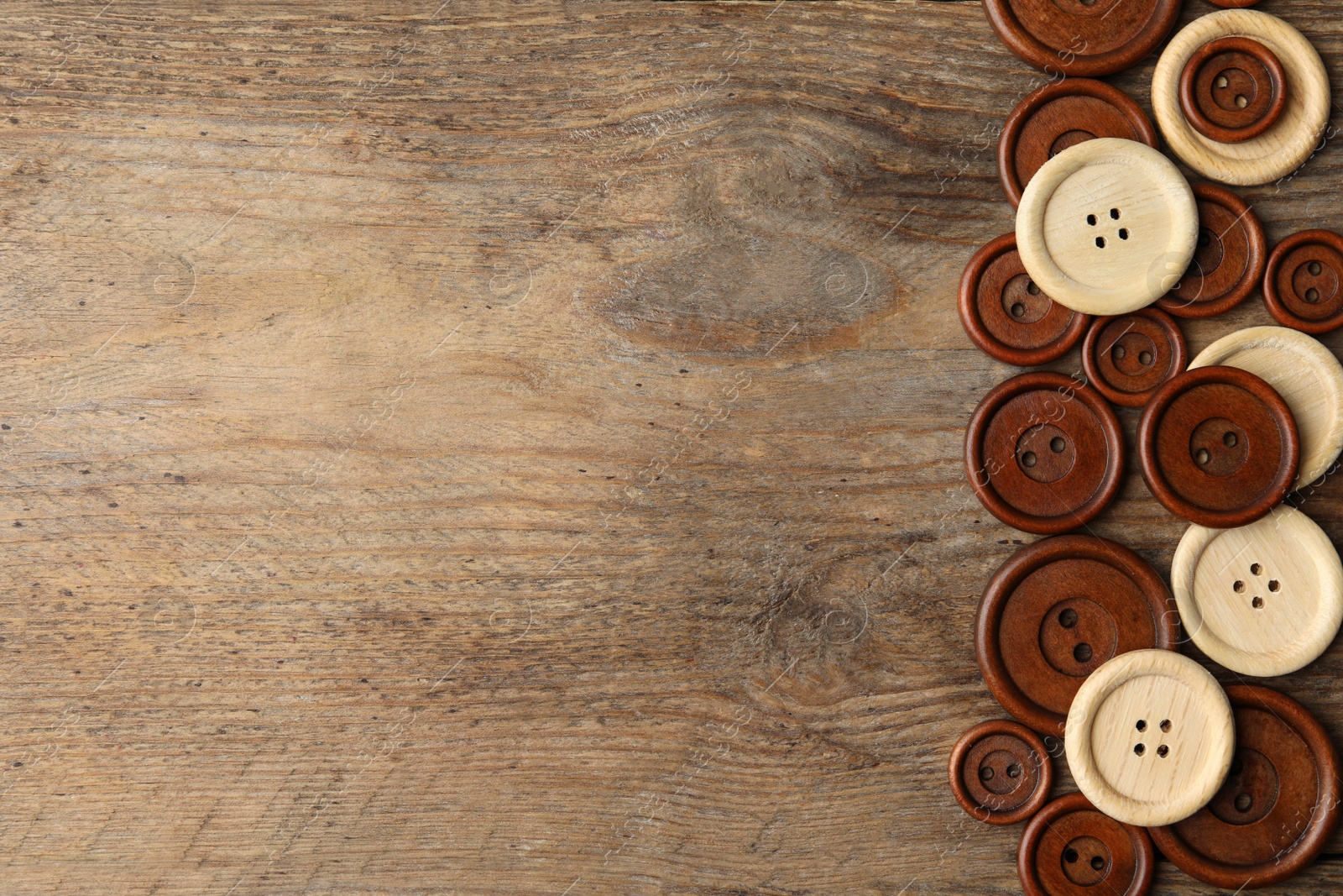 Photo of Many sewing buttons on wooden background, flat lay. Space for text