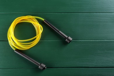 Photo of Skipping rope on green wooden table, top view. Space for text