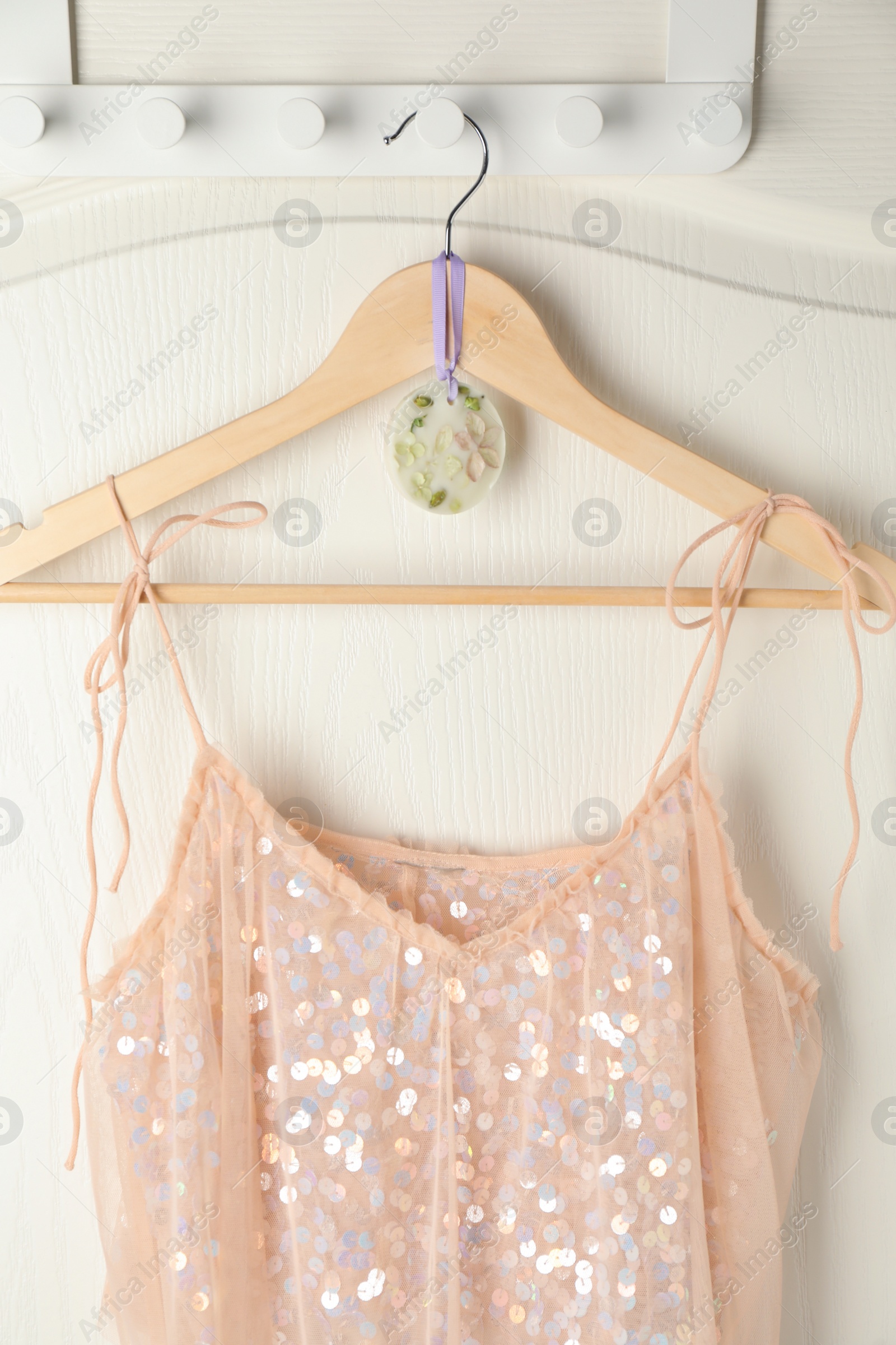 Photo of Scented sachet with flowers and stylish clothes on hanger