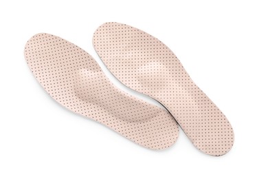 Photo of Beige orthopedic insoles isolated on white, top view